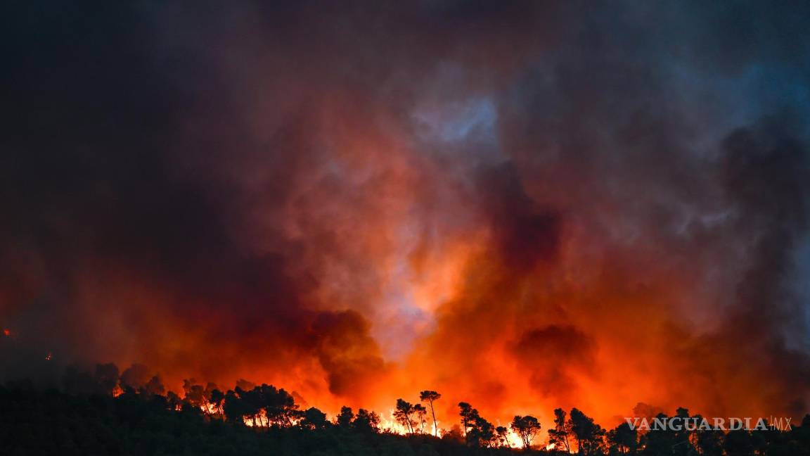 $!Las llamas envuelven una zona boscosa durante un incendio forestal en Saint-Laurent-de-la-Cabrerisse, departamento de Aude, Francia.