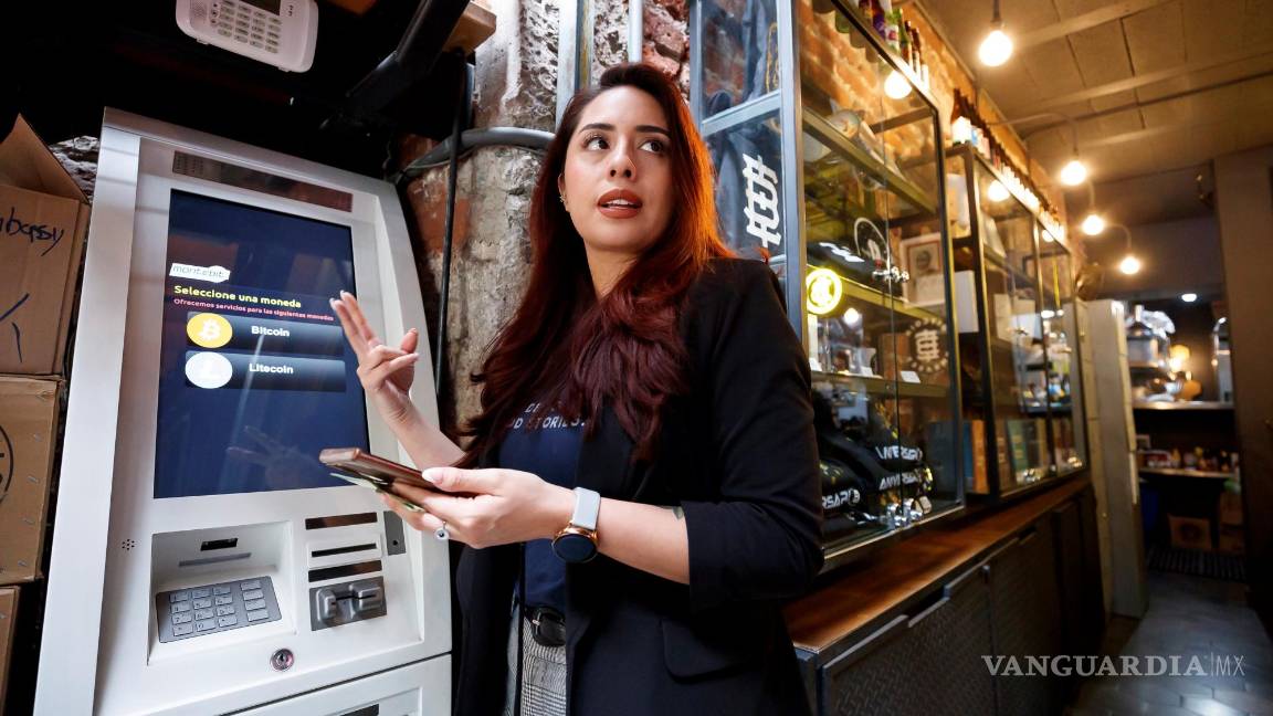 $!La cofundadora del Bitcoin Embassy Bar, Lorena Ortiz, muestra el funcionamiento de un cajero automático de bitcoin en Ciudad de México. EFE/José Méndez