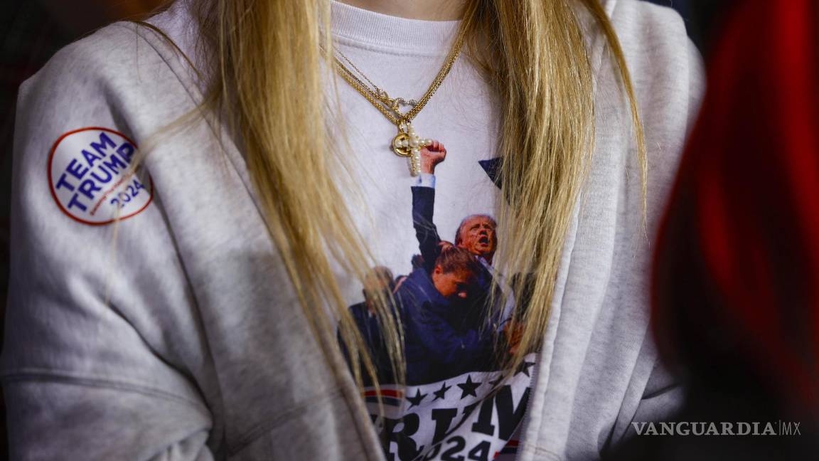 $!Una mujer escucha al candidato presidencial republicano Donald Trump en un mitin de campaña en el aeropuerto del condado de Dodge en Juneau, Wisconsin.