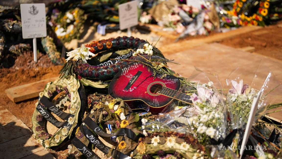 $!Una guitarra y coronas de flores en la tumba del soldado Ilai Azar tras su funeral en el cementerio de Kiryat Shaul en Tel Aviv, Israel, el 14 de octubre de 2023.