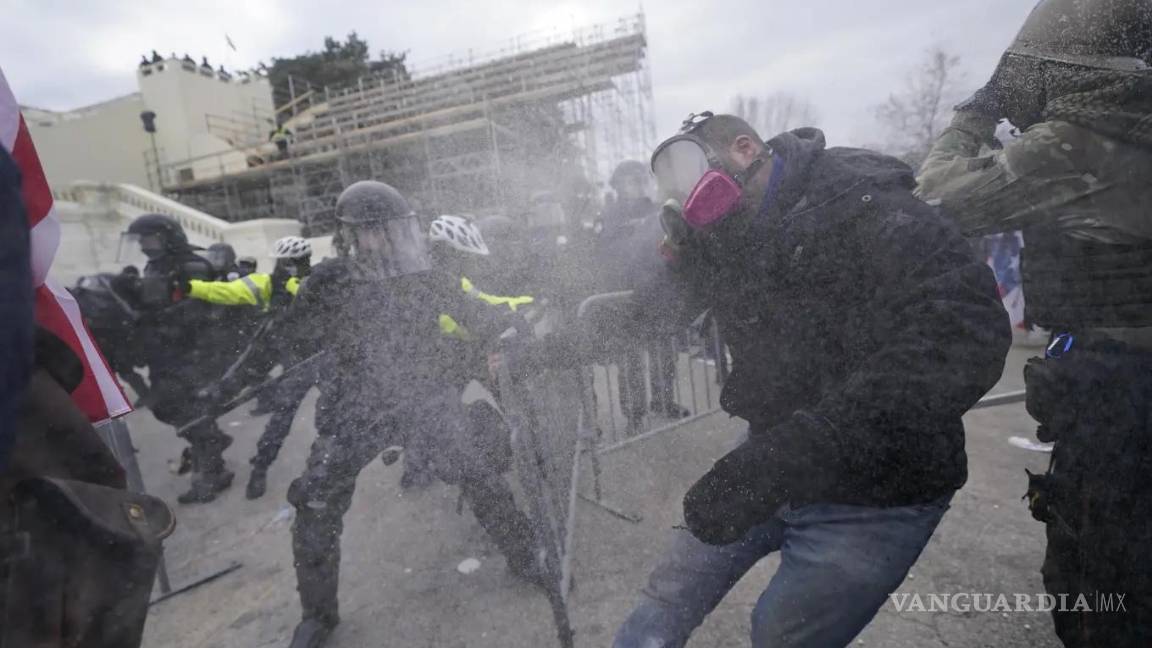 $!Partidarios del entonces presidente Donald Trump intentan atravesar una barrera policial en el Capitolio en Washington el 6 de enero de 2021.