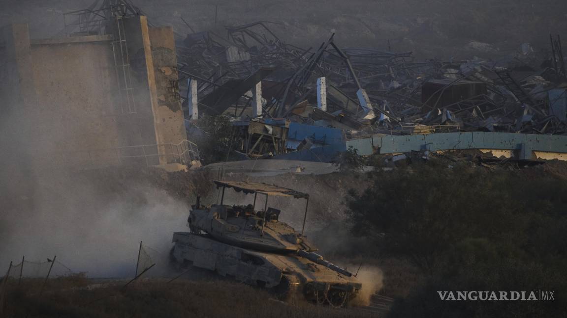 $!Soldados israelíes conducen un tanque dentro de la Franja de Gaza visto desde el sur de Israel.