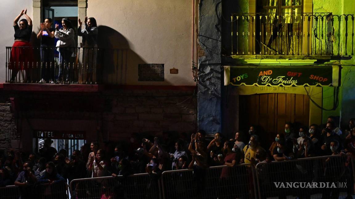 $!Personas intentan observar la inauguración del Festival Cervantino mientras en un balcón un grupo de mujeres bailan con la música de Los Vam Vam. Cuartoscuro/Daniel Augusto