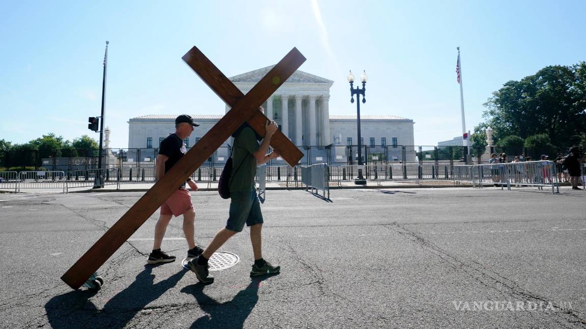 $!Una persona lleva una cruz frente a la Corte Suprema en Washington.