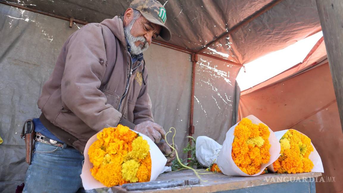 $!Miguel Núñez, comerciante de flores, se prepara para atar ramos de cempasúchil.