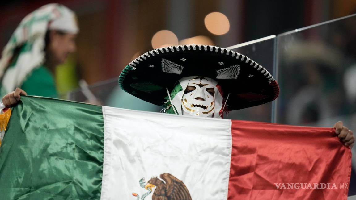 $!Un hincha mexicano sostiene su bandera nacional durante el partido de fútbol entre México y Polonia, en el Estadio 974 en Doha, Qatar.