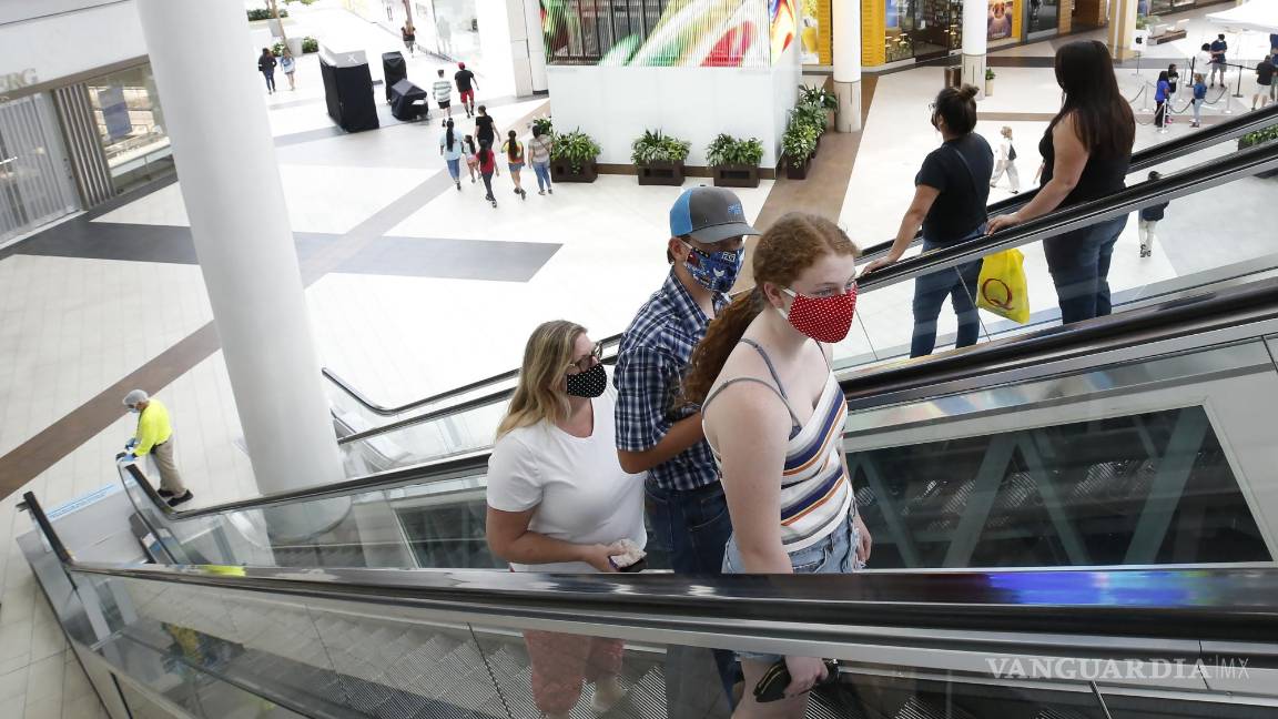 $!Imagen del 29 de mayo de 2020, personas con cubrebocas toman una escalera mecánica hasta el segundo piso del Arden Fair Mall en Sacramento, California.