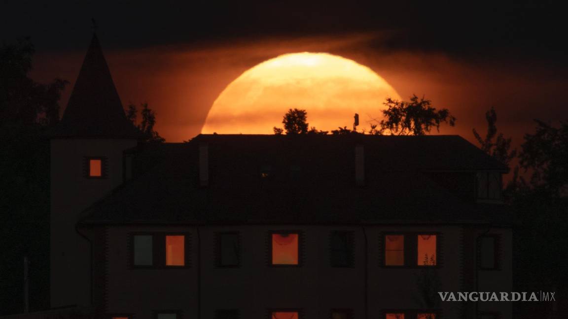 $!La luna llena, detrás de una casa en la localidad de Putilovo, a 70 kilómetros (43 millas) al este de San Petersburgo, Rusia, el 13 de julio de 2022.