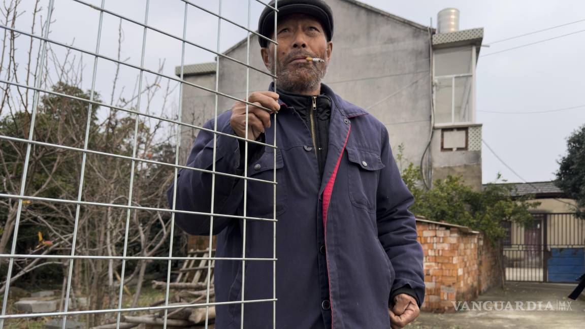 $!Yang Guoliang de pie en la puerta delante de su casa en Changzhou, en la provincia oriental china de Jiangsu.