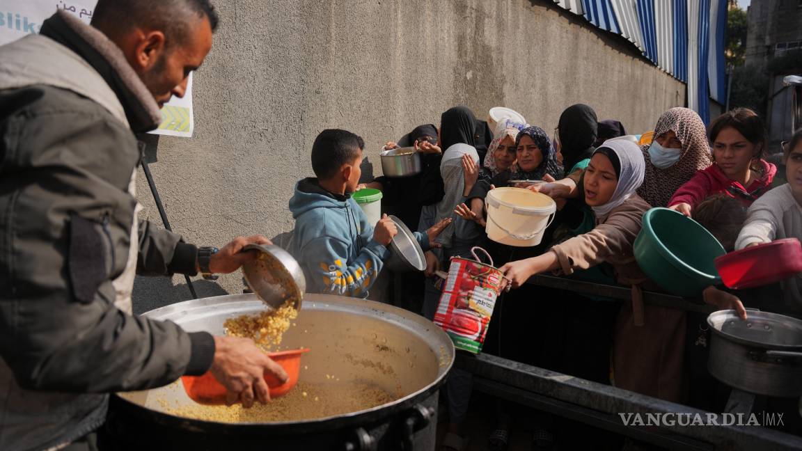 $!Mujeres palestinas luchan por recibir alimentos donados en un comedor comunitario en Nuseirat, en el centro de la Franja de Gaza.