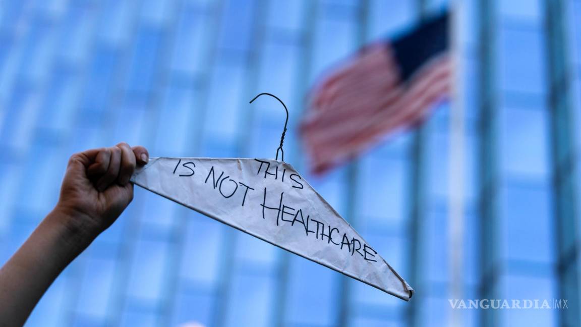 $!Una mujer sostiene un gancho de ropa para simbolizar los abortos ilegales y peligrosos en una protesta en pro del derecho en Los Ángeles.