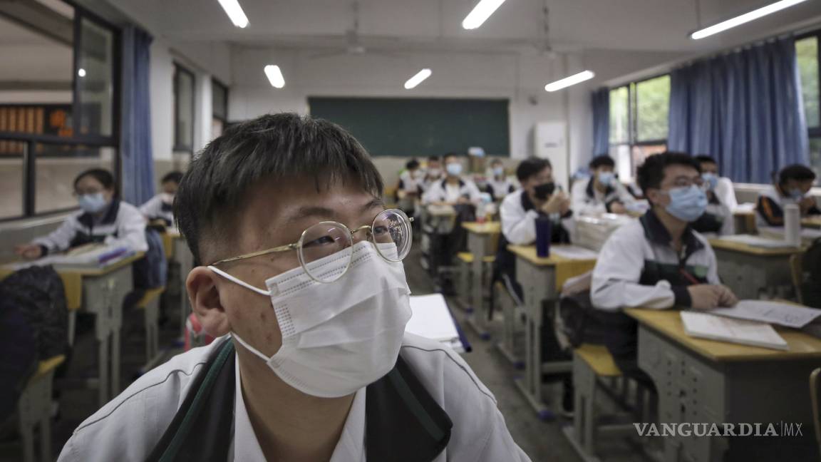 $!Con brazaletes electrónicos miden la temperatura a estudiantes en Pekín