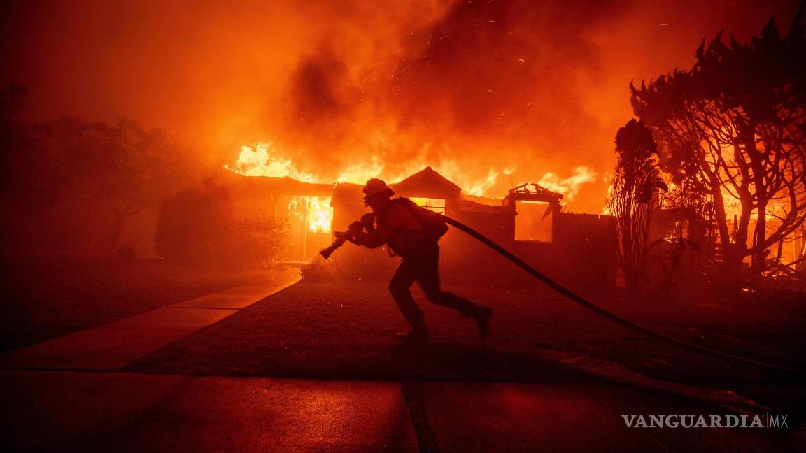 $!Un bombero lucha contra el incendio de Palisades mientras quema una estructura en el vecindario de Pacific Palisades en Los Ángeles.
