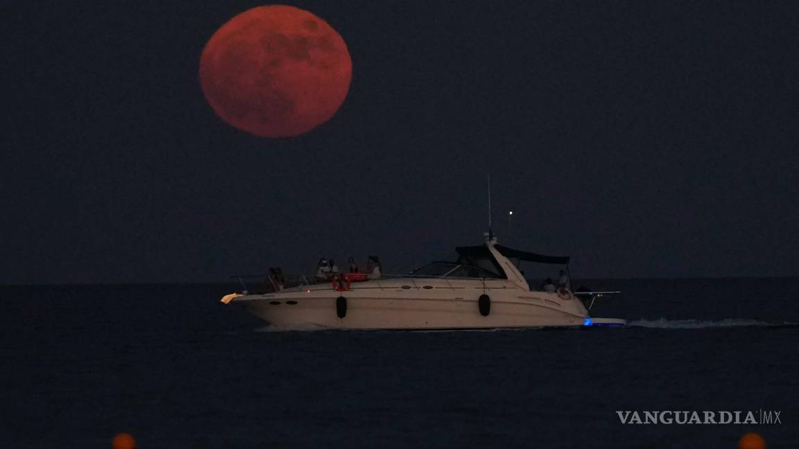 $!La luna llena se eleva sobre un barco en la ciudad mediterránea de Larnaca, en el sureste de Chipre, el 13 de julio de 2022.
