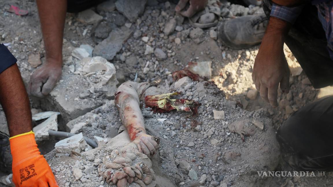 $!En la imagen ee ve el brazo de una persona fallecida entre los escombros tras un ataque israelí-estadounidense contra una escuela primaria de niñas en Minab, Irán