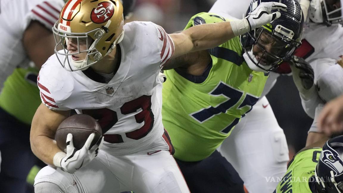 $!El corredor de los San Francisco 49ers, Christian McCaffrey (23), corre contra el tackle defensivo de los Seattle Seahawks, Quinton Jefferson.