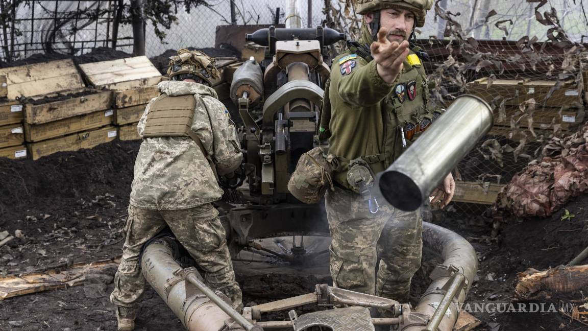 $!Un soldado arrojó un proyectil gastado humeante mientras una unidad de artillería ucraniana disparaba su obús móvil contra una posición rusa.