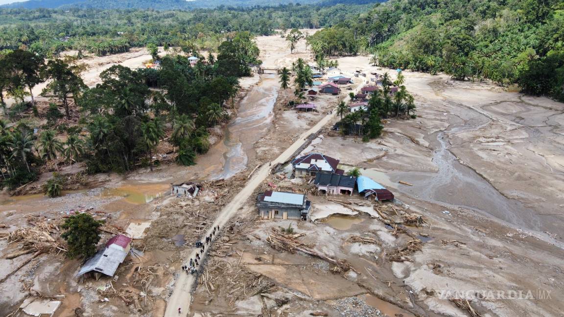 $!Personas caminan por una carretera en un pueblo afectado por una inundación repentina en Batang Toru, Sumatra del Norte, Indonesia, el 1 de diciembre de 2025.