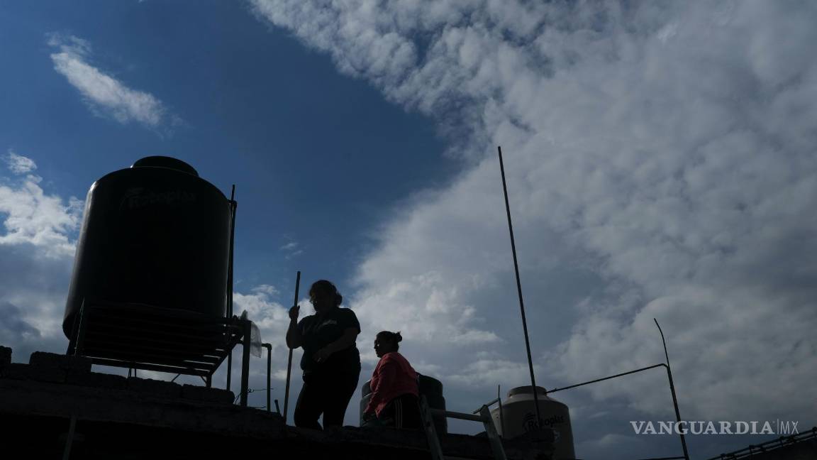 $!Sonia Estefania Palacios Díaz (i), Sara Huitzil Morales (d) propietaria de la vivienda, limpian el techo de una casa para recolectar agua de lluvia en la colonia Iztapalpa.
