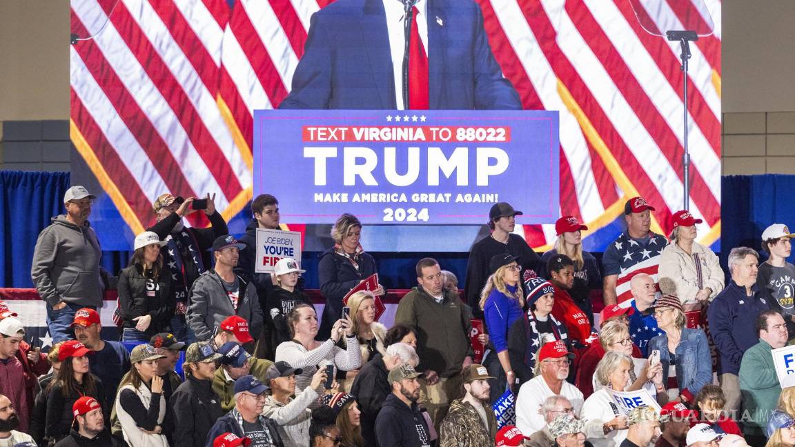 $!Partidarios escuchan a Donald Trump mientras le ven en un monitor mientras habla durante un mitin de campaña del Súper Martes en Richmond, Virginia.
