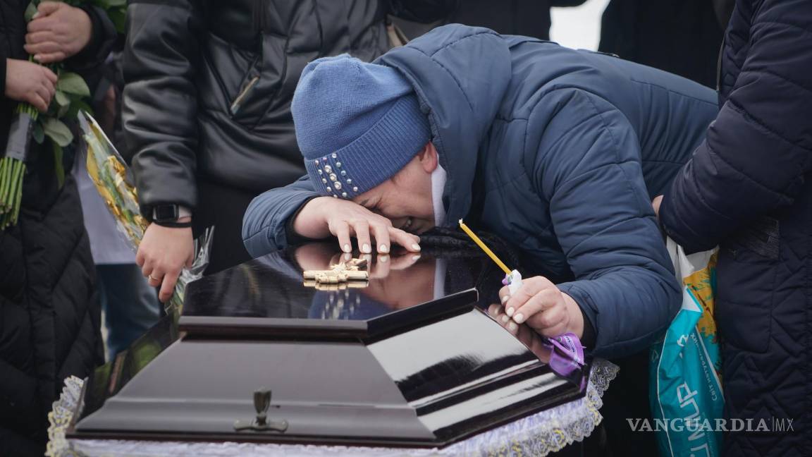 $!Los familiares lloran ante los ataúdes de una familia que murió en un incendio cuando un dron ruso impactó su casa en un barrio residencial en Kharkiv, Ucrania.