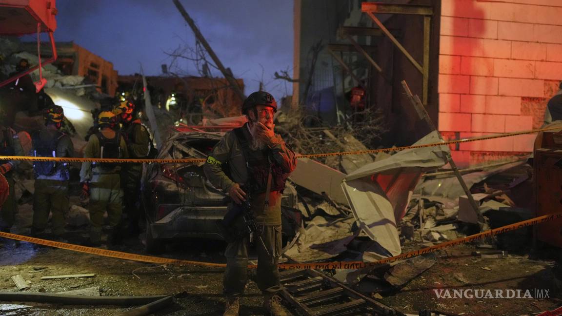 $!Las fuerzas de seguridad israelíes inspeccionan los edificios destruidos por un misil lanzado desde Irán, cerca de Tel Aviv, Israel.