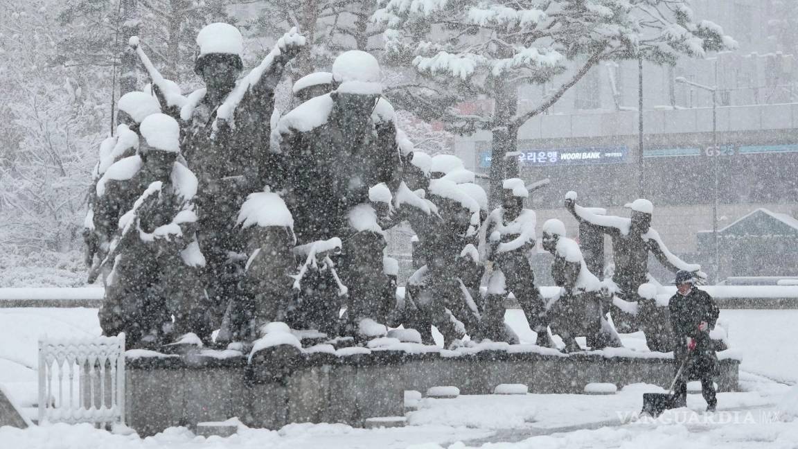 $!Un trabajador quita nieve con una pala cerca de un monumento en recuerdo de la Guerra de Corea en el Museo Memorial de la Guerra de Corea en Seúl.