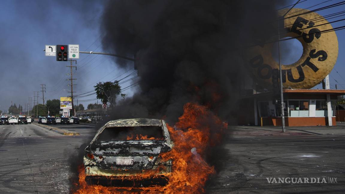$!Un vehículo arde en llamas durante una protesta después de que autoridades federales de inmigración llevaron a cabo una redada, el sábado 7 de junio de 2025, en Compton, California. (AP Foto/Eric Thayer)
