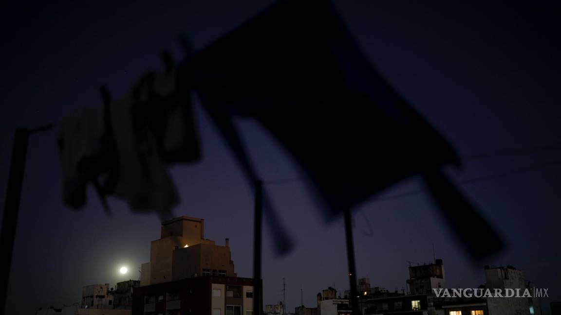 $!Ropa tendida para secarse en una terraza mientras la luna llena se eleva sobre Buenos Aires, Argentina, el miércoles 13 de julio de 2022.