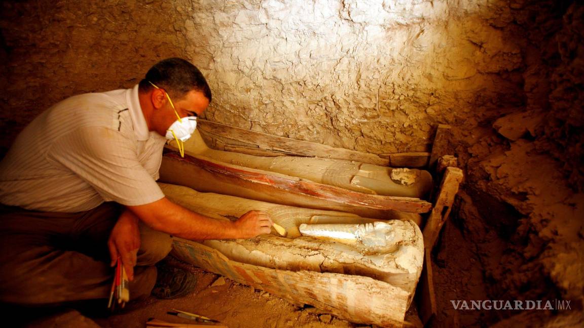 $!Un arqueólogo egipcio limpia un féretro de madera que contiene una momia cubierta con un trapo de lino, en la pirámide Illahun de la localidad egipcia de Faiyum. EFE/Khaled El-Fiqi