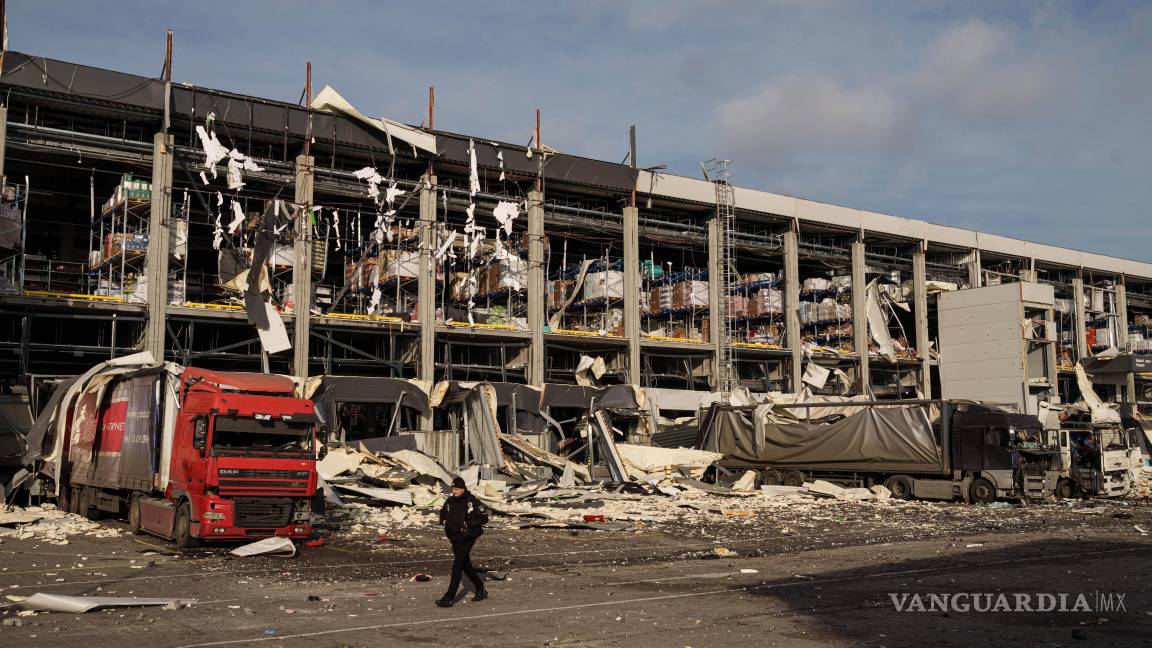$!Un agente de policía camina frente a un centro logístico de Novus dañado tras un ataque ruso en Kiev, Ucrania.