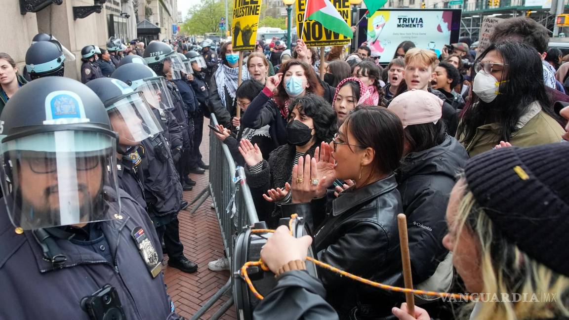 $!Agentes de policía de la ciudad de Nueva York hacen guardia mientras los manifestantes corean consignas frente al campus de la Universidad de Columbia.