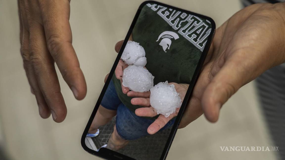 $!El gerente de una tienda de Denha &amp; Sons, Inc. muestra una foto de granizo del tamaño de una pelota de béisbol durante una tormenta en Davison, Michigan.