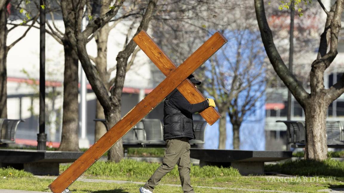 $!Dan Beazley de Michigan camina con una cruz antes de una vigilia realizada por las víctimas del tiroteo en The Covenant School en Nashville, Tennessee.