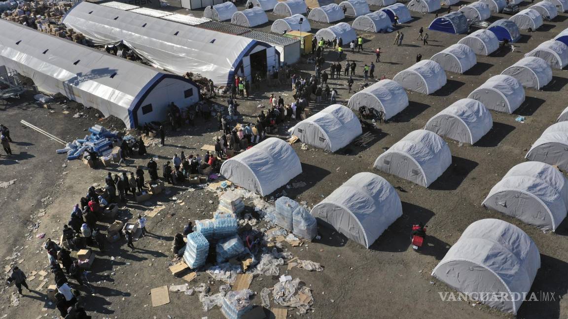 $!Personas que perdieron sus viviendas por un sismo devastador hacen fila para recibir víveres en un campamento improvisado, en Alejandreta.