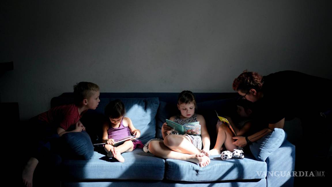 $!Anastasia Domini (d) ayuda a su hija Una a leer, junto a sus hermanos Aksinia, Mikhail y Agata, en su casa de Buenos Aires, Argentina.