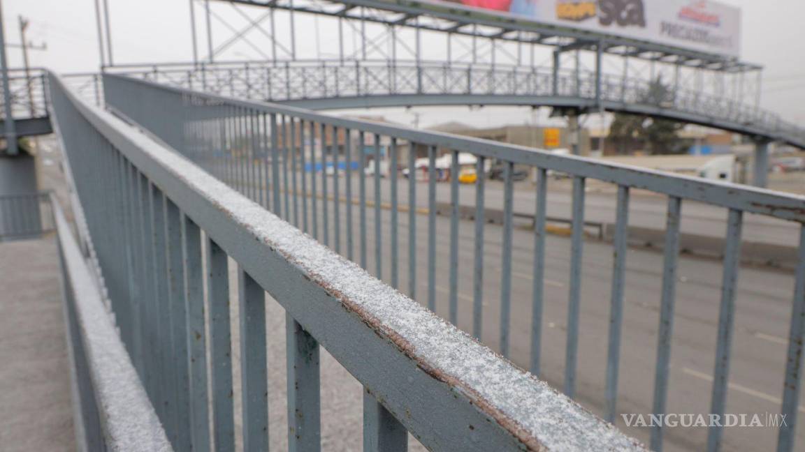 $!La caída de aguanieve complica sujetarse del barandal.