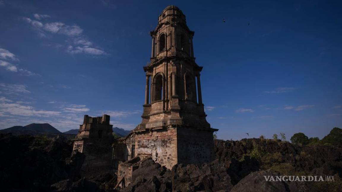 $!La torre de una iglesia sobresale por encima de la lava del volcán Paricutín que enterró la iglesia hace décadas, en San Juan Parangaricutiro, en Michoacán.