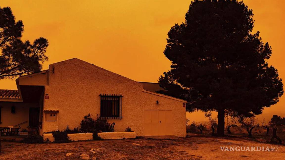 $!En la imagen se ve el cielo color naranja sobre una casa en Navares, España, debido al polvo de Sahara.