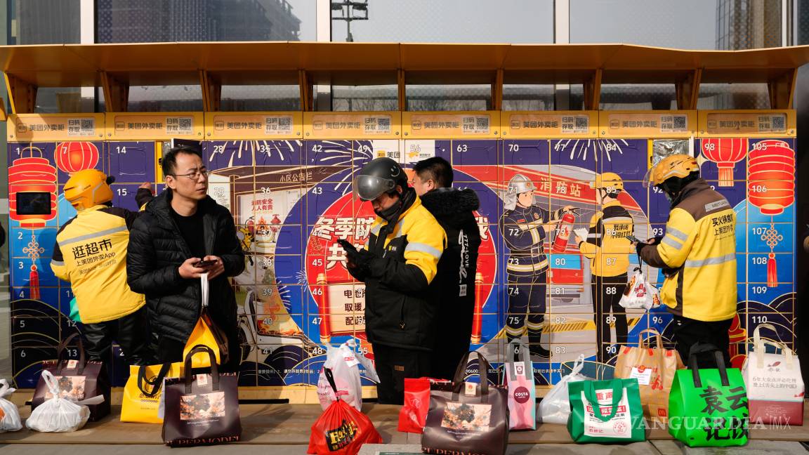 $!Repartidores dejan sus paquetes en una taquilla en Pekín, China, el 15 de enero de 2026.