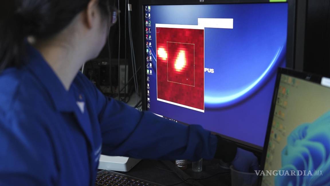 $!Naixin Qian amplía una imagen generada a partir de un escaneo microscópico, con nanoplásticos que aparecen como puntos rojos brillantes en Nueva York.