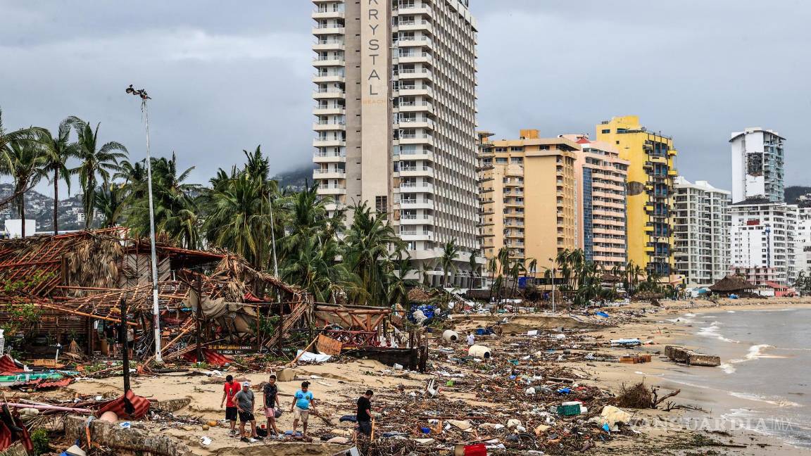 $!Vecinos caminan entre los escombros arrojados en la playa por el huracán Otis en el balneario de Acapulco, en el estado de Guerrero, México.