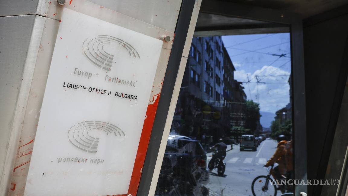 $!El tráfico en la calle se refleja junto a un cartel dañado del Parlamento y la Comisión Europea en Sofía, Bulgaria.