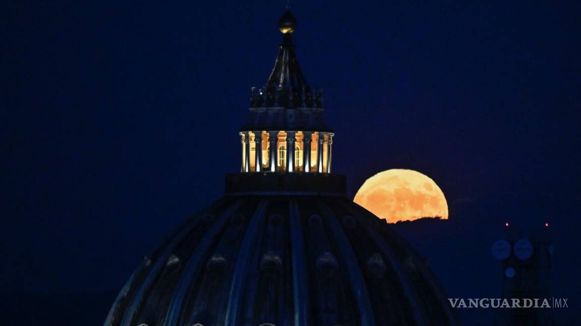 $!La Súper Luna llamada “Luna del Ciervo” se eleva en el cielo detrás de la cúpula de la Basílica de San Pedro en la Ciudad del Vaticano vista desde Roma, Italia.