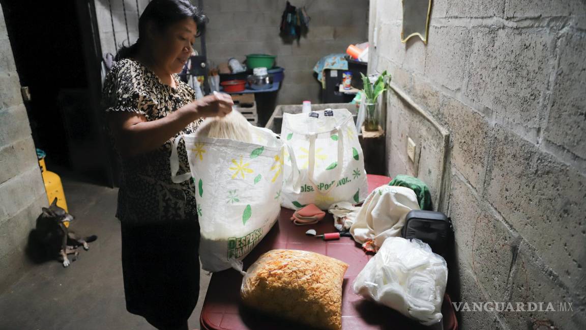 $!María Concepción Ventura prepara un paquete para su hija Juana Guadalupe Recinos, una madre soltera de dos hijos que está en la cárcel, en Santa Ana.