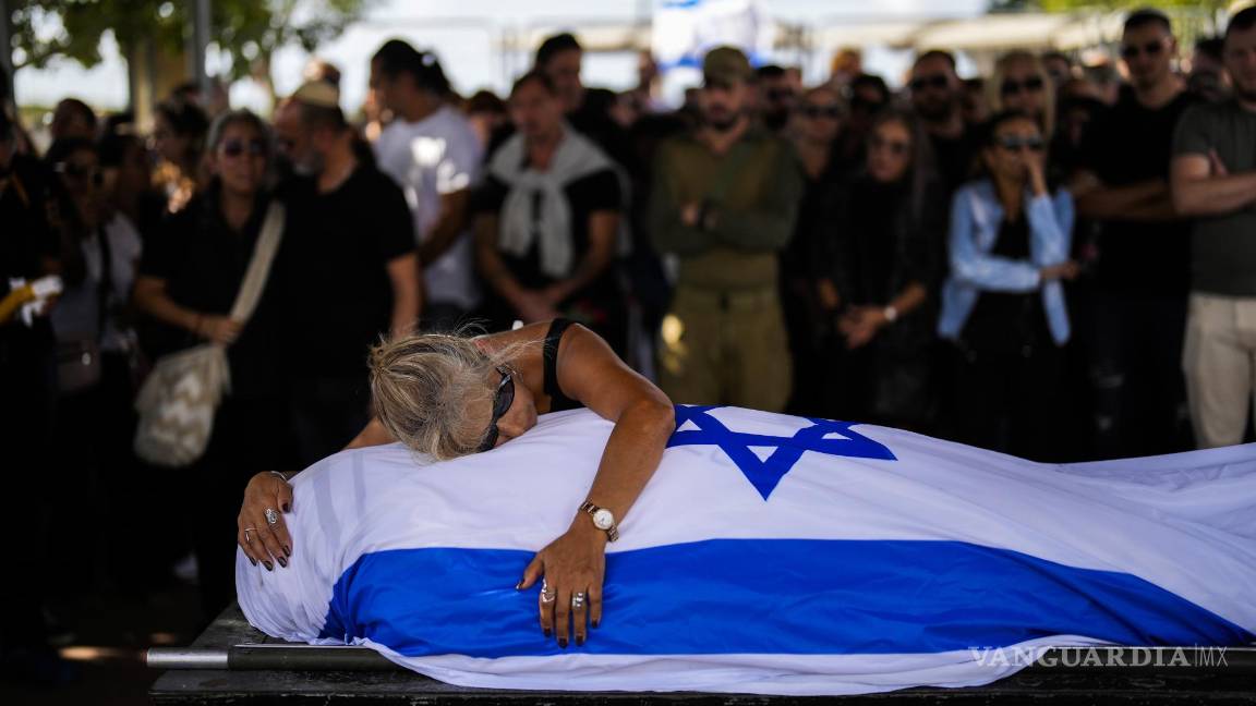 $!La madre de Antonio Macías llora sobre el cadáver de su hijo, cubierto con la bandera de Israel, en el cementerio Pardes Haim, en Kfar Saba, cerca de Tel Aviv.