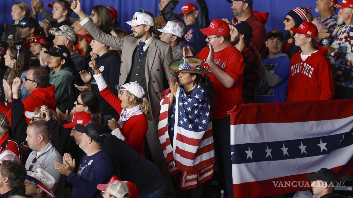 $!Partidarios aplauden mientras Donald Trump habla en un mitin de campaña en el aeropuerto del condado de Dodge en Juneau, Wisconsin.