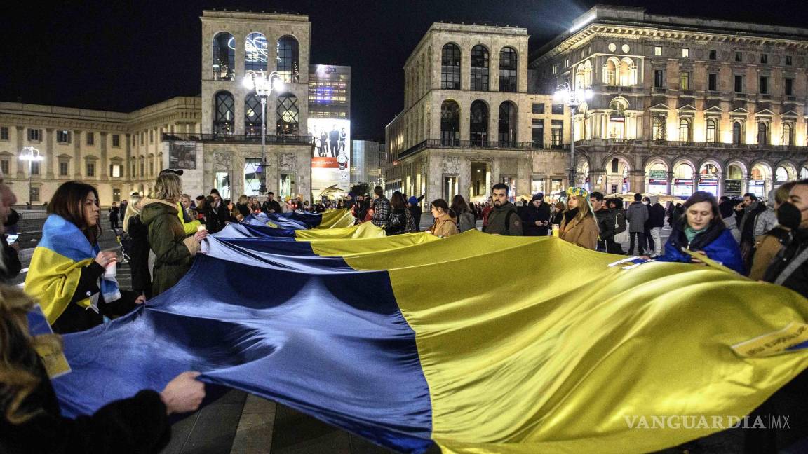$!La gente lleva una enorme bandera ucraniana durante una protesta contra la agresión rusa a Ucrania, en Milán, Italia. EFE/EPA/Andrea Fasani