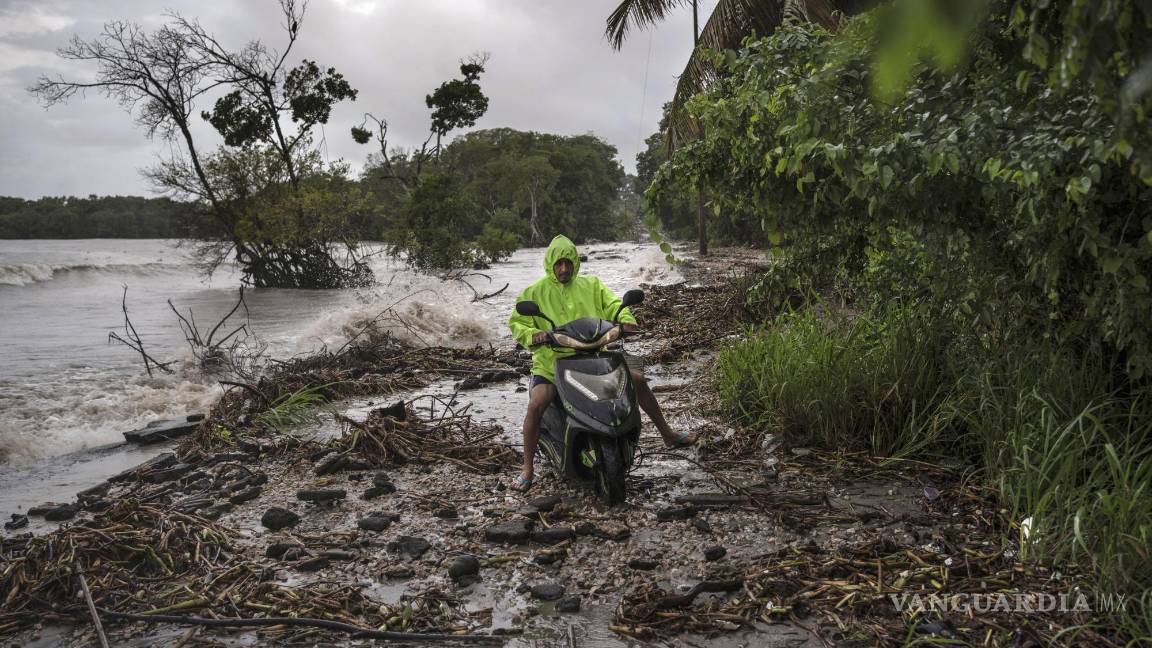 $!Delmer Torres conduce su motocicleta por una carretera cubierta por escombros en su comunidad costera de El Bosque, en el estado de Tabasco, México.