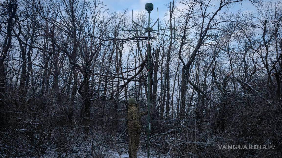 $!Un soldado ucraniano instala una antena de un sistema de guerra electrónica para escuchar el parloteo ruso en la línea del frente cerca de Bakhmut.